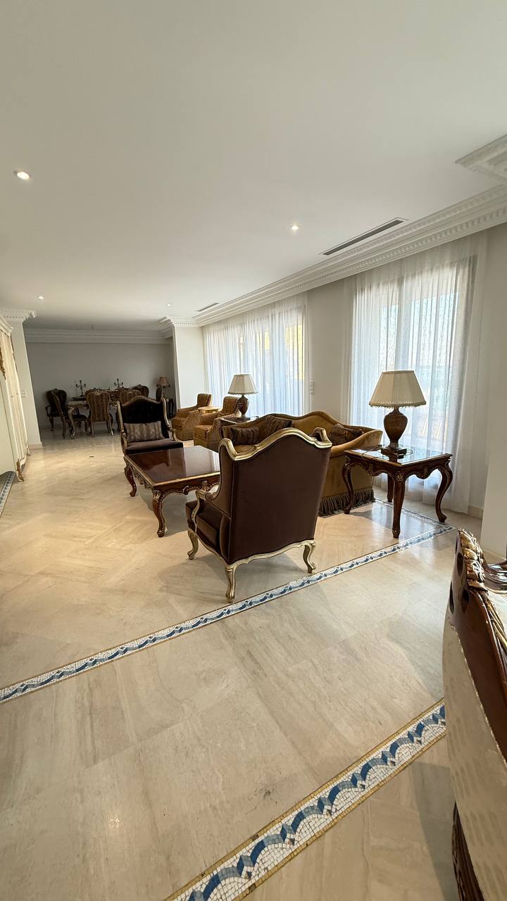 Salón clásico con visillos blancos en los ventanales y vistas al jardín