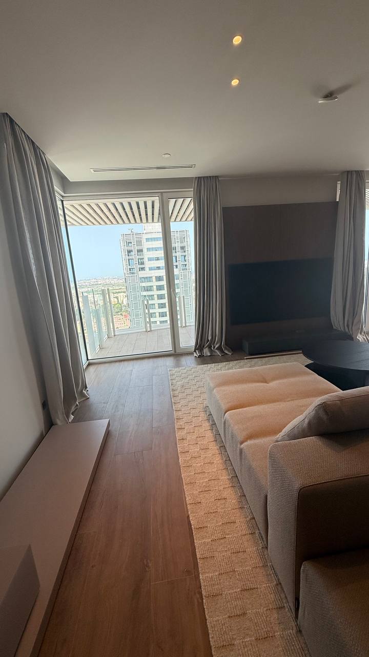 Salón con cortinas grises junto a la salida a la terraza