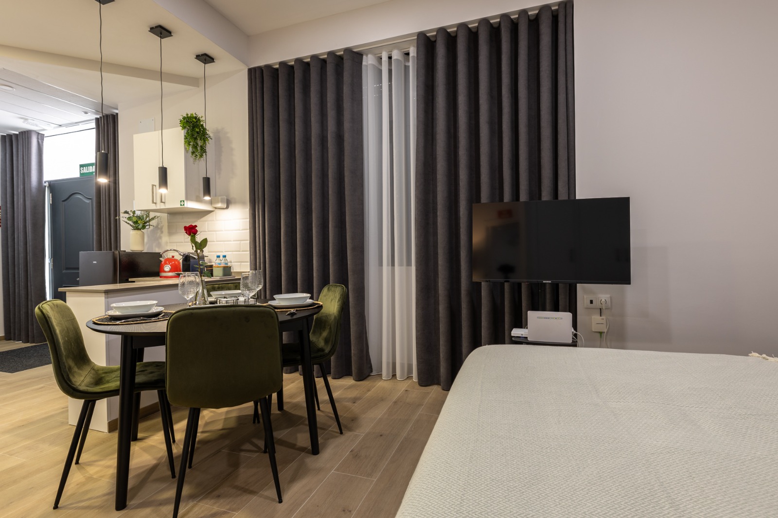Cortinas grises de suelo a techo con visillo blanco en un apartamento estudio