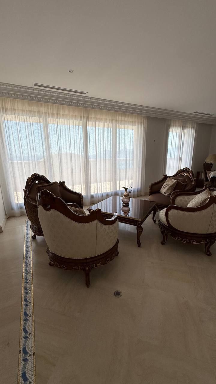 Sala de estar con visillos claros en ventanal panorámico con vistas al mar