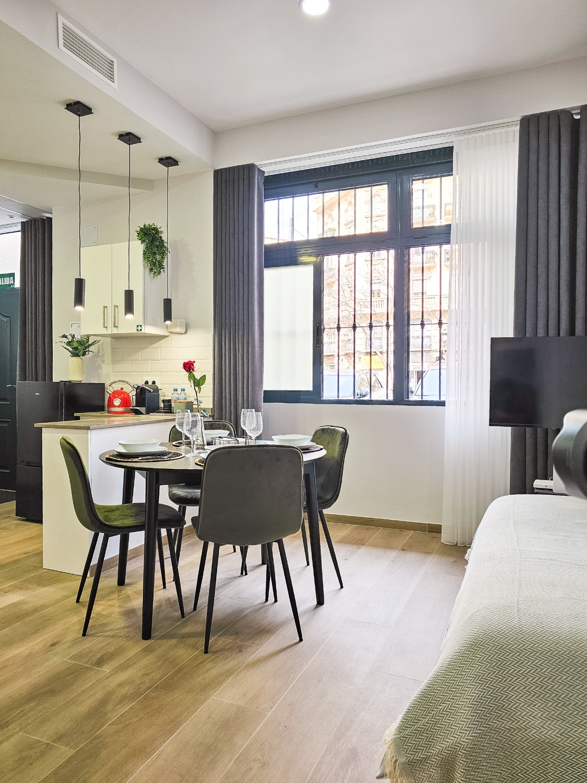 Estudio con cortinas grises y visillo blanco en la ventana junto a la cocina