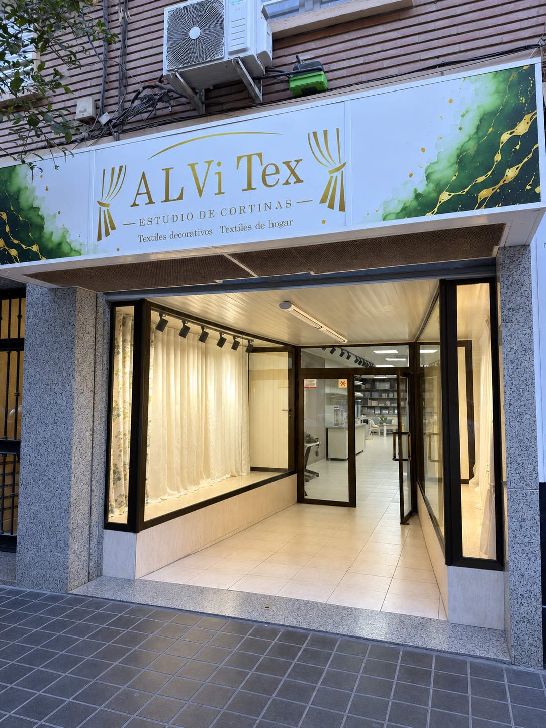 Fachada y escaparate del showroom ALViTex en Carrer de Higinio Noja 18, València, con cortinas y visillos expuestos