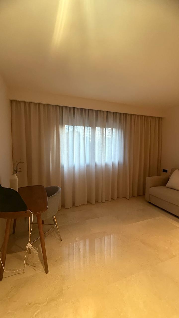Cortinas beige de caída larga en una habitación cálida