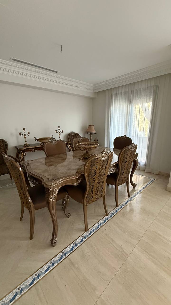 Comedor con visillo blanco fruncido en la puerta de la terraza